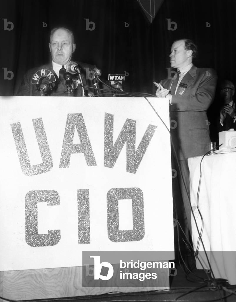 AFL president George Meany addressed Convention of the United Auto Workers-CIO. March 29, 1955. UAW President Walter Reuther is at right. The top item on Meany's 1955 agenda was merging the AFL with the CIO (Congress of Industrial Organizations). He achieved this in Dec. 1955