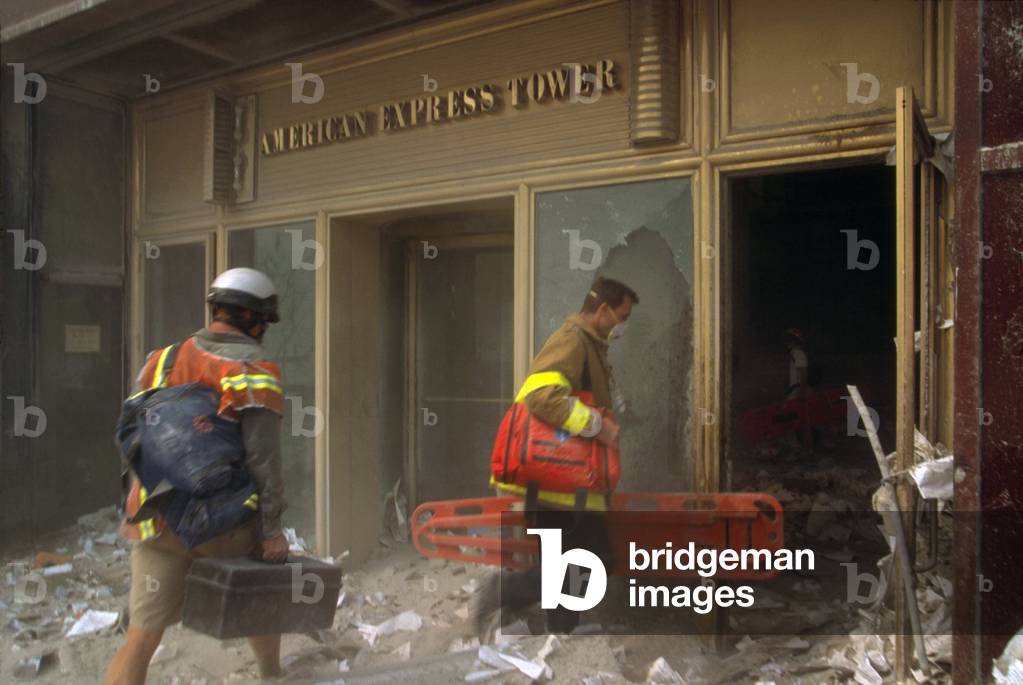 Rescue workers enter the American Express Tower, World Financial Center 3, following 9-11 terrorist attack. They carry orange litters into the debris battered building across the West Side Highway from the World Trade Center complex
