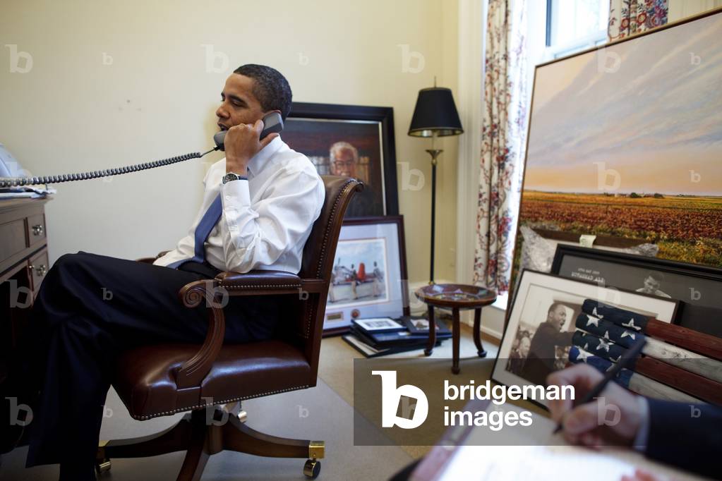 President Barack Obama takes a phone call in his private study off the Oval Office on Feb. 3 2009. His personal items include portraits of Thurgood Marshall Martin Luther King and Muhammed Ali.,