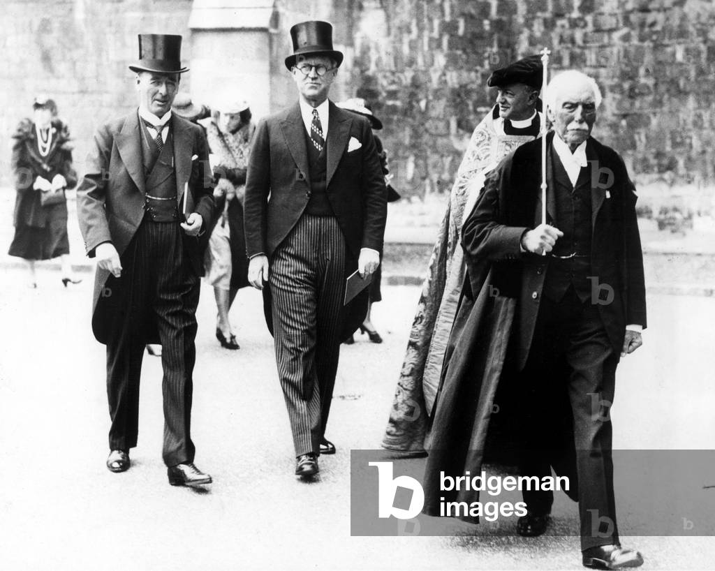 WINCHESTER, ENG: Joseph P. Kennedy (center), U.S. Ambassador to Britain, walking with Lord Mottistone (left), Lord Lieutenant of Hampshire, and the Very Rev. Dr. E.G. Selwyn (right, partly obscured) Dean of Winchester, 7/18/38.