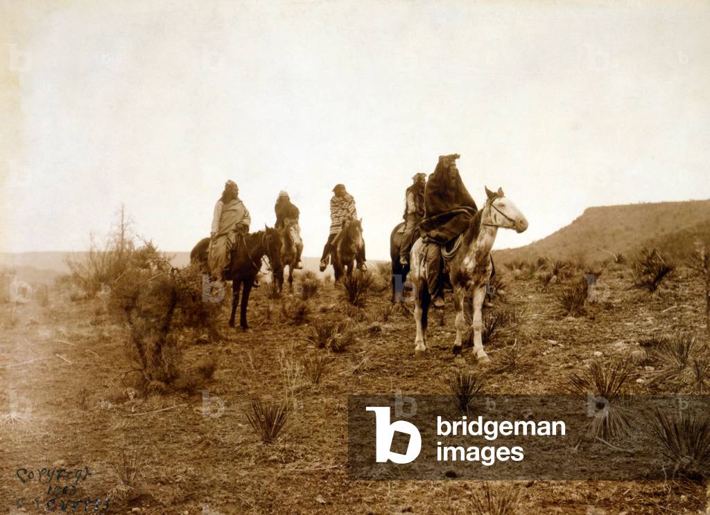 Apaches. Desert rovers- Five Apache on horseback in desert. photo by Edward S. Curtis, 1903