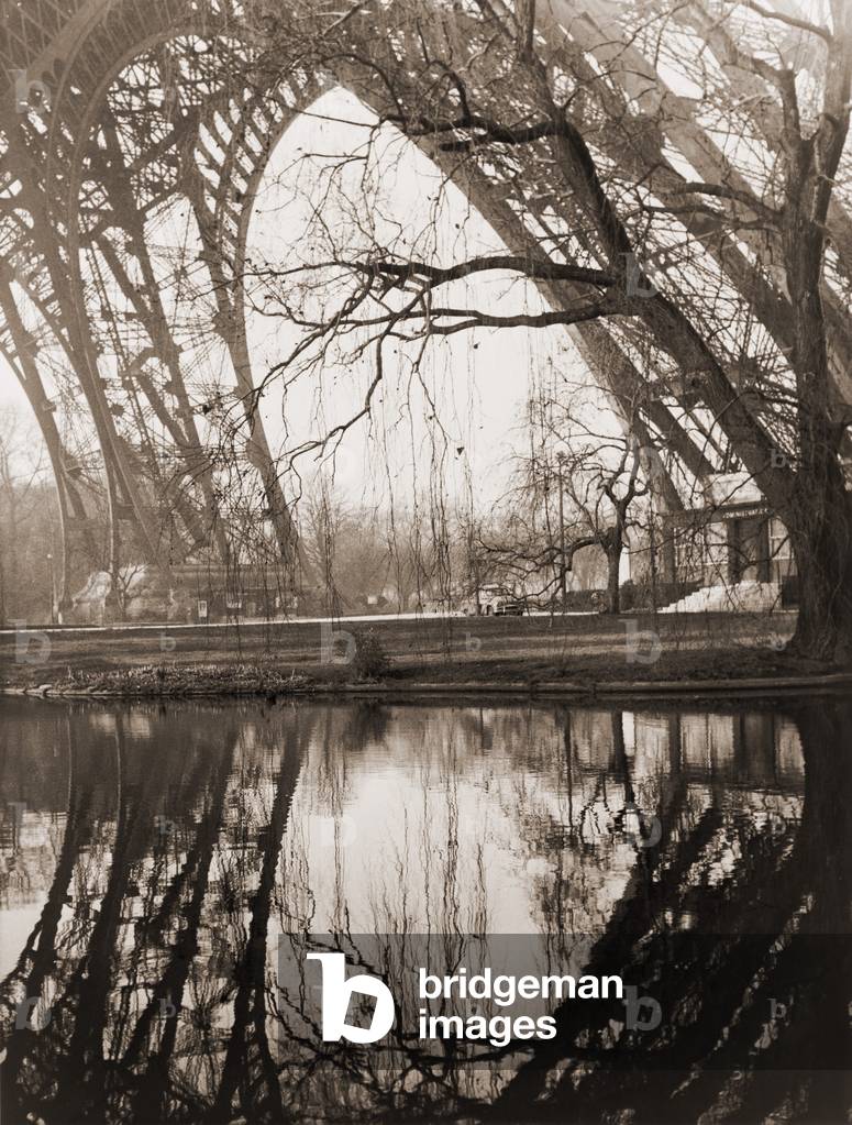 A rare unpopulated winter view of the girders of the Eiffel Tower reflected in the placid waters beneath the tower in Paris. February 1961