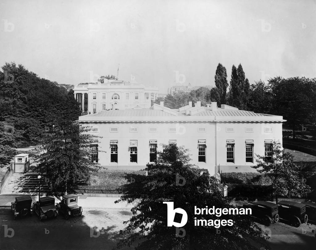 West Wing of the White House was built as a temporary office building in the first year of the Theodore Roosevelt presidency. Roosevelt's six children left little room for the President's administration. He held the first meeting in the Cabinet room on Nov. 6 1902. Photo with old cars was probably taken before 1920