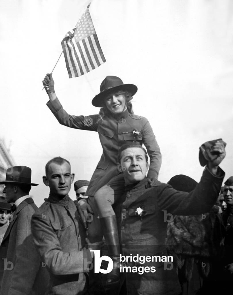 Mary Pickford, greeted by her boy who has just returned from France. Private Kenneth Harlan (143rd Artillery) holds Mary on his shoulder, 1918