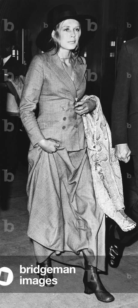 Singer Marianne Faithful at Heathrow Airport after arriving from Dublin, June 26, 1970. She wears a newly fashionable menswear suit with a maxi skirt and a snake skin coat. On June 24, it was announced that she plans to marry a British peer. Lord Rossmore, a 39 year old architectural photographer. -