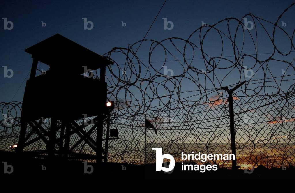 The sun sets on Camp X-Ray's first day as an active compound on Jan. 11 2002. Camp X-Ray later renamed Camp Delta was the holding facility for prisoners from Afghanistan believed to be associated with Al-Qaeda or the Taliban at Naval Base Guantanamo B, Photo by:Everett Collection