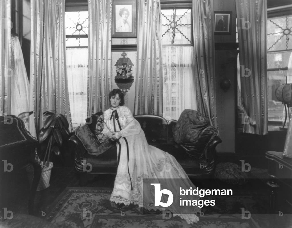 Margaret Anglin, (1876-1958), Canadian born actress, seated on sofa in a elaborately decorated living room. 1903 photo by Joseph Byron