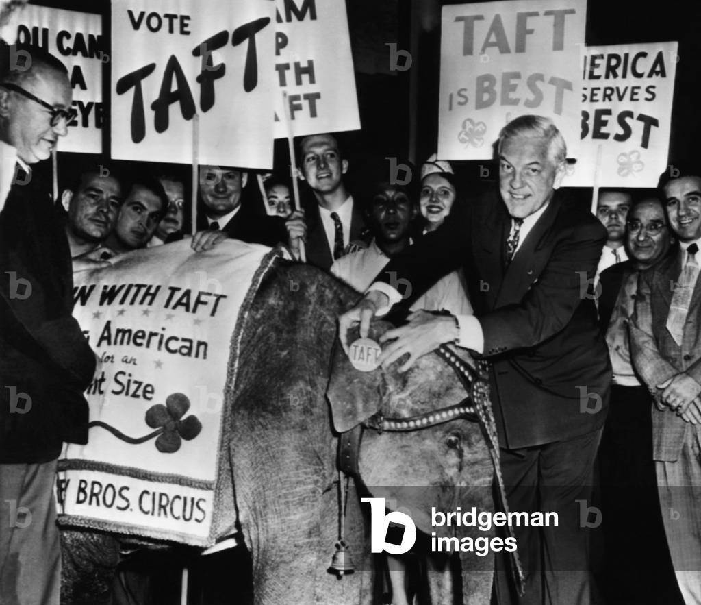 US Elections. Right, next to elephant: Ohio Governor Thomas J. Herbert holding 'Taft' button next to Republican mascot, Eva, in support of US Senator Robert Taft, at the Republican National Convention, Philadelphia, Pennsylvania, June 1948