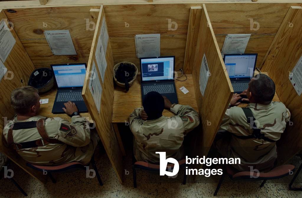 Soldiers and airmen in Iraq check their e-mail at Camp Caldwell Iraq. Nov. 19 2004