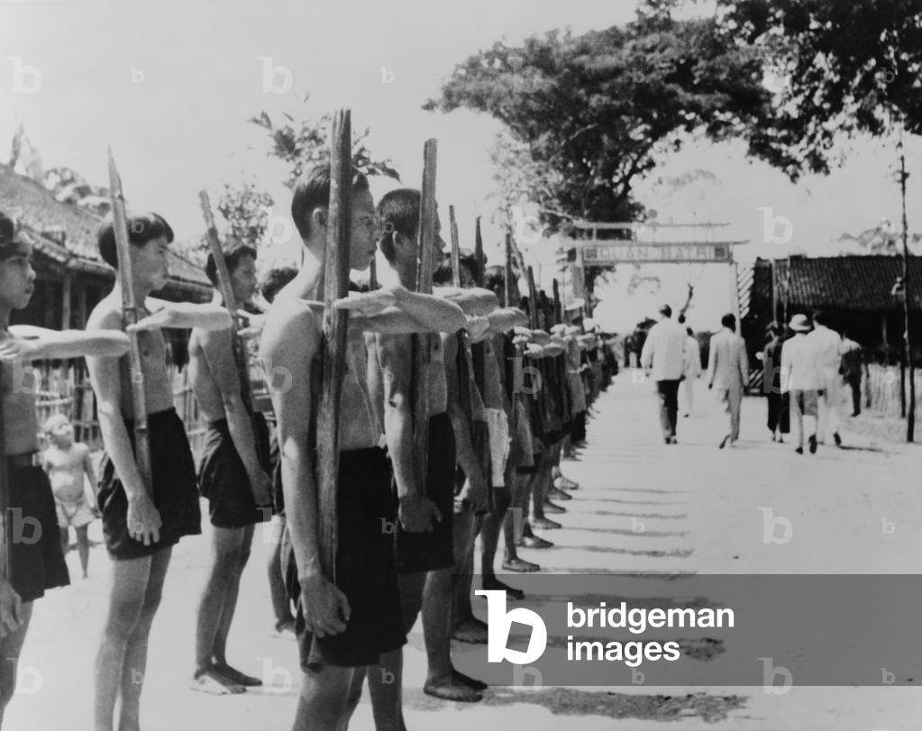 Barefoot villagers perform training drills using 'bamboo rifles', Batri, French Indochina, 1951 (photo)