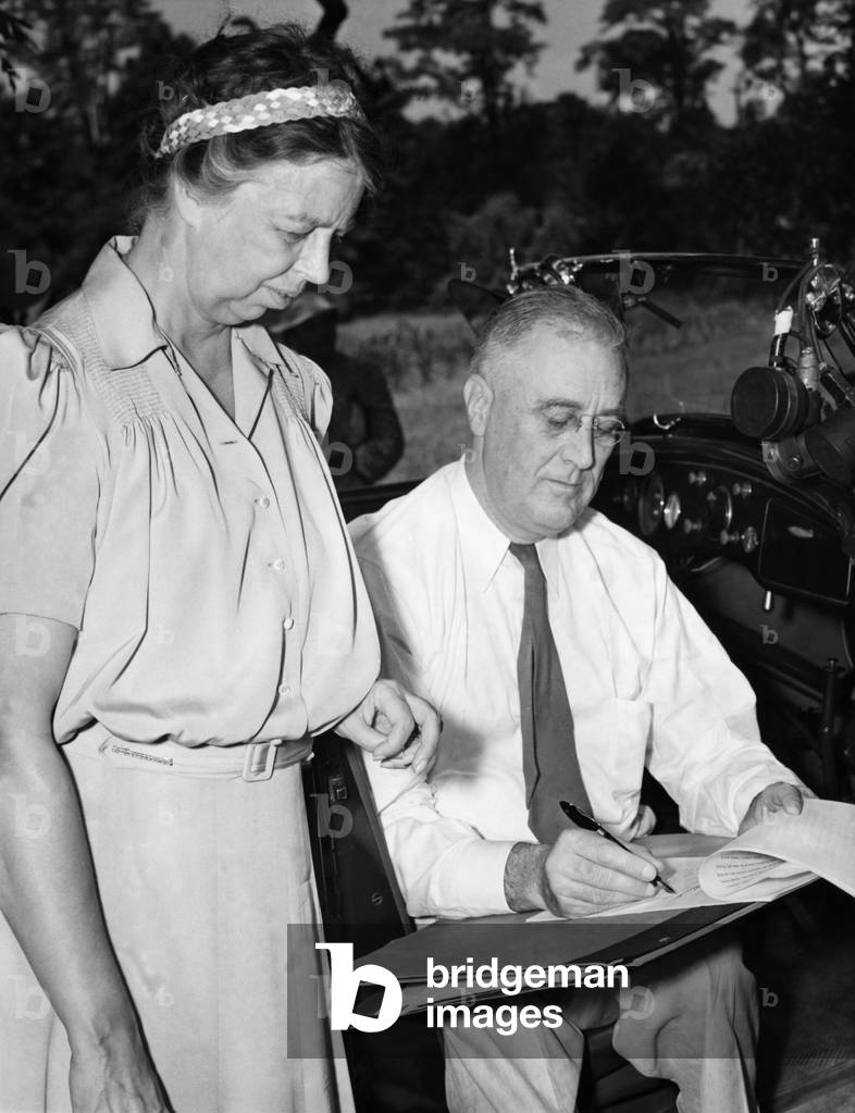FDR Presidency. First Lady Eleanor Roosevelt watching US President Franklin Delano Roosevelt signing a deed donating land in Hyde Park, NY for Roosevelt's Presidential library, late 1930s