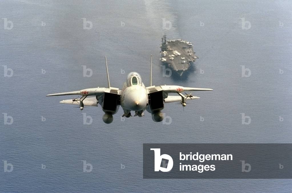 F-14 Tomcat fighter just after take-off from the aircraft carrier USS AMERICA is armed with missiles mounted on wing pylons. 1984