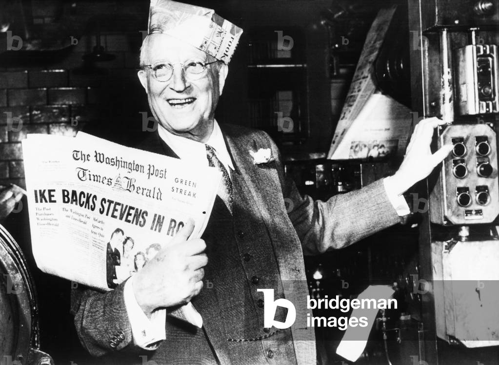 Eugene Meyer holds the first copy of the new Washington Post and Times Herald. March 17, 1954. The chairman of the Board of the Washington Post, wore a pressman's hat to celebrate the merger of the two newspapers