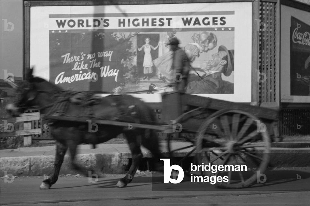 Horse drawn cart against an billboard in Memphis during the 1937 flood. The politically motivated pro-business reads 'World's Highest Wages-These No Way Like the American Way'. Feb. 1937