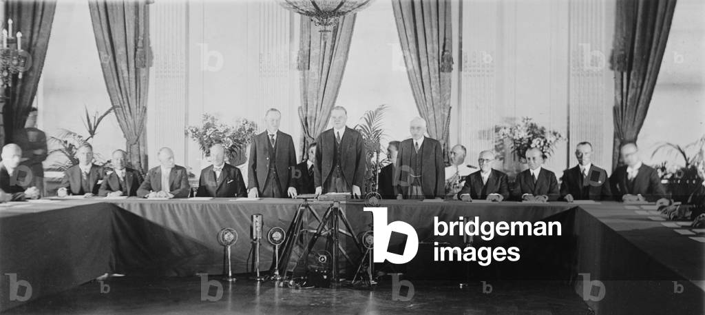 President Calvin Coolidge (1872-33) Herbert Hoover 1874-1964), standing, with diplomats who have ratified the Treaty for Renunciation of War (Kellogg-Briand Pact), in the East Room of the White House, July 24, 1929
