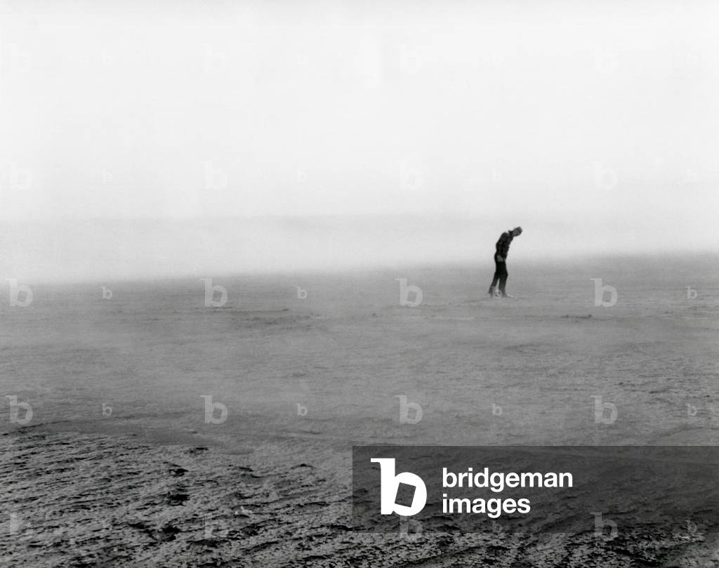 Native pasture land blowing in Dixon, South Dakota, May 1936. Figure in the distance in bent forward to resist the force of the wind