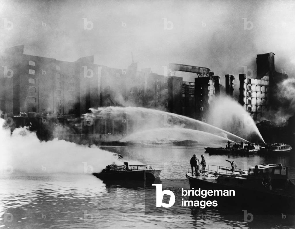 London Firemen direct water from their fireboats onto blazing warehouse. The Germans bombed the port facilities on the London waterfront. 1940, during the Battle of Britain, World War 2