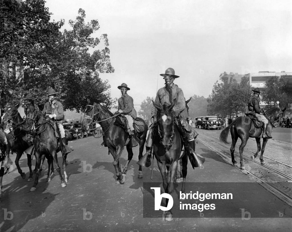 Gas Masked cavalry on Pennsylvania Avenue reinforce Washington DC police. Bonus Army veterans resisted police evictions from their shanty town on Anacostia Flats. The troops would use tear gas against the veterans in their camp. July 28, 1932
