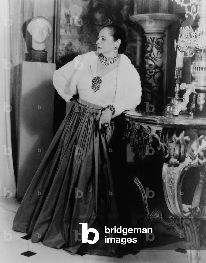 Helena Rubinstein 1870-1965 Polish born cosmetics entrepreneur wearing dramatic jewelry in the dining room of her New York City apartment c. 1940