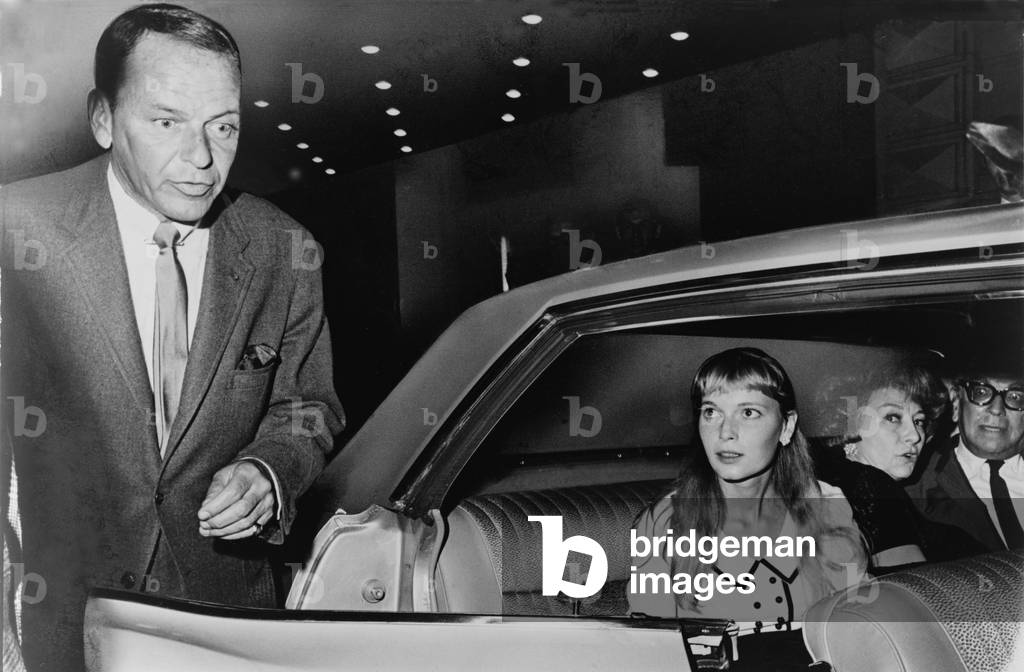 Frank Sinatra (1915-98) and Mia Farrow (b. 1945) prepare to leave the Schubert Theater in New York, in August 1965. The couple were married in July 1966