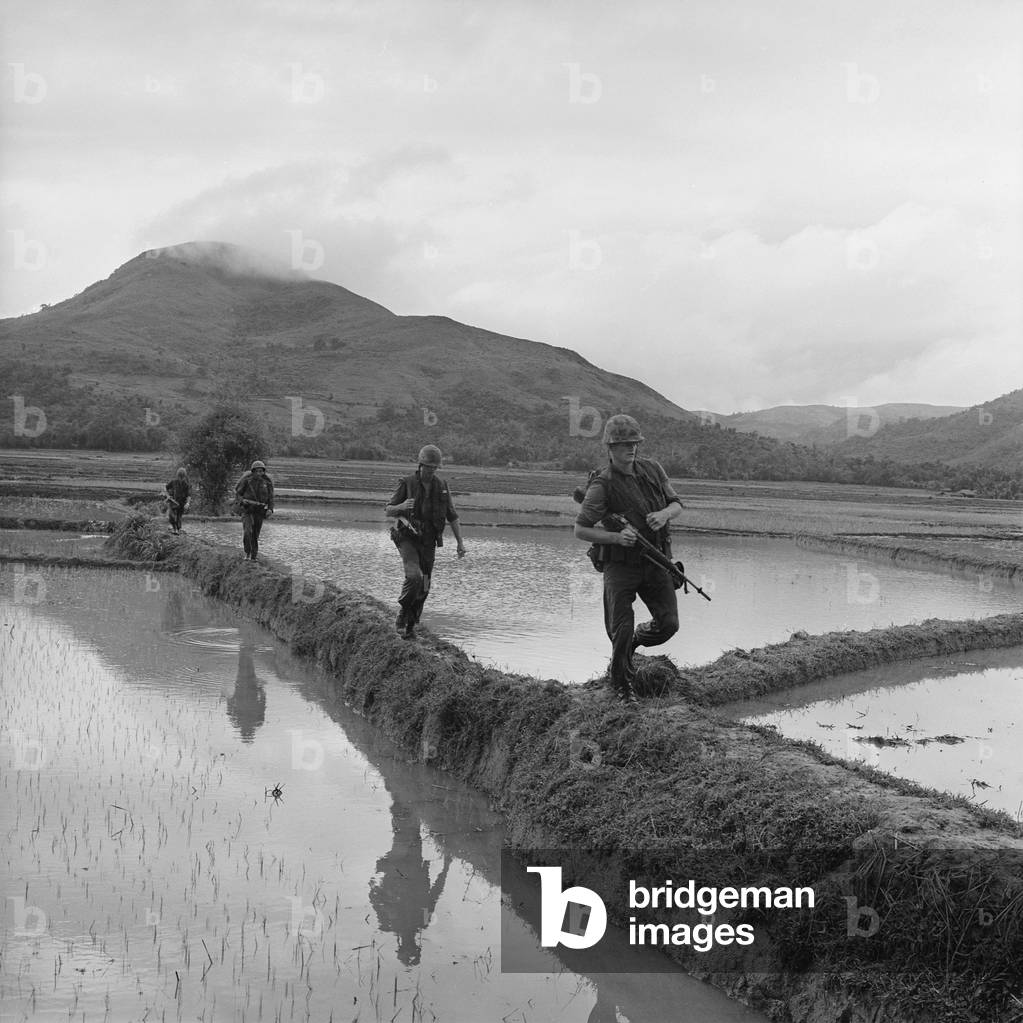Vietnam War. US Marines move along rice paddy dikes in pursuit of the Viet Cong. Dec. 10, 1965