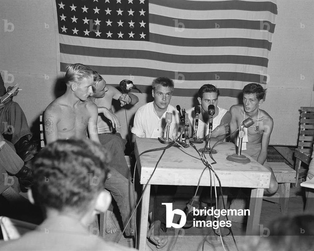 American POWs released during 'Operation Big Switch' being interviewed by the press. They display their camp mascot 'Oscar' a pet magpie at 'Freedom Village', where UN repatriated POWs were processed for return to their homes. Communists call use 'Peace Village' as their name for the prisoner exchange center. Sept. 1953. Korean War, 1950-53