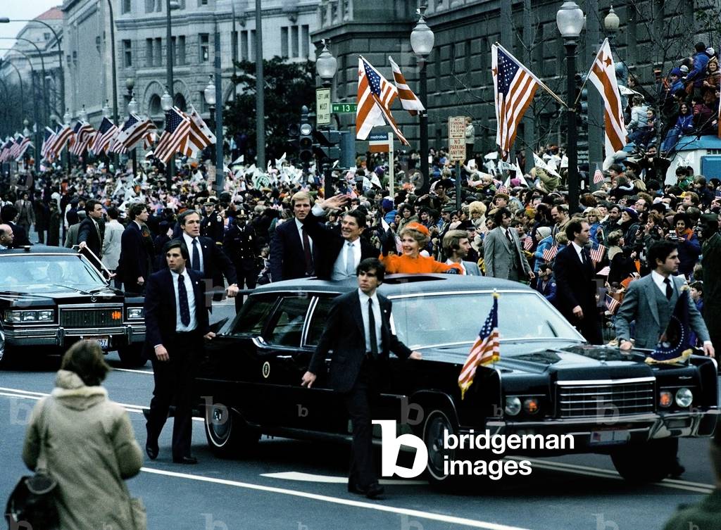 President and Mrs. Reagan wave to crowds as they ride in the presidential car during the Inauguration Day parade. Jan 20 1981