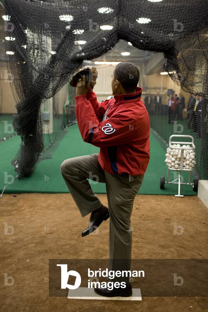 President Barack Obama warms up before throwing out the ceremonial first pitch on opening day of baseball season at Nationals Park in Washington D.C. April 5 2010.,