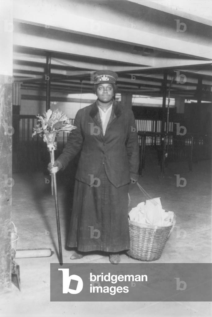 New York City, African American woman porter posed with cleaning gear, subway worker standing, New Y: New York City, African American woman porter posed with cleaning gear, subway worker standing, New York, photograph, 1917.