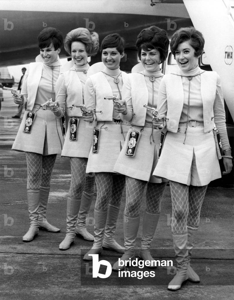 LONDON: These Western Air Lines hostesses are packing pisotls for a reason. They are not trying to keep visitors out of the country but are here to encourage tourists to visit the United States. April 29, 1968.