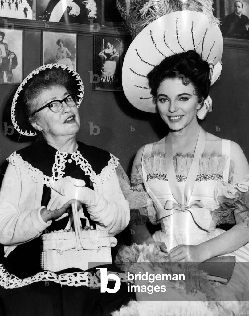 Evelyn Nesbit (left), visiting the movie set where Joan Collins (right) is portraying her in the film 'The Girl In The Red Velvet Swing', 1955.