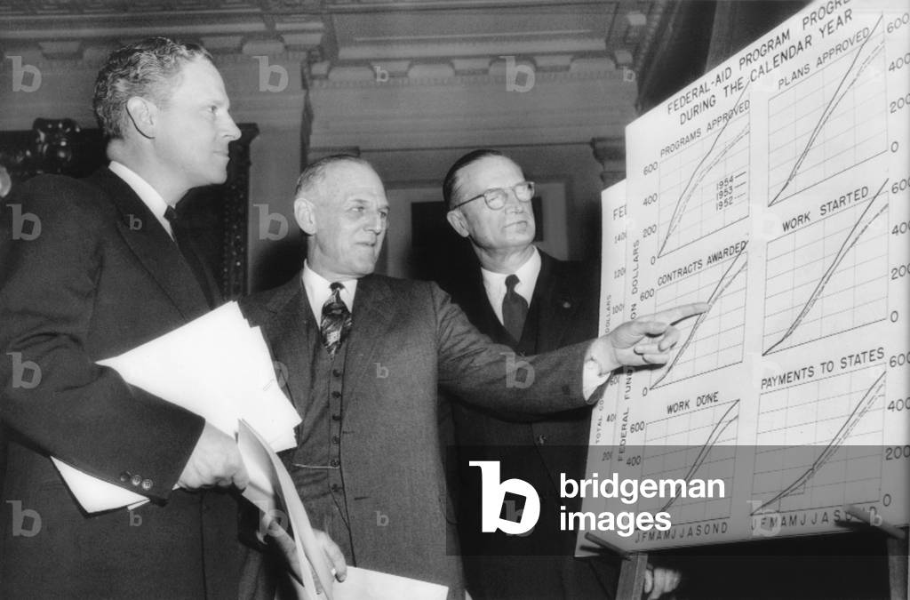 Senate Public Works Subcommittee hearings on Pres. Eisenhower's interstate road building program. The program appeared headed for bumpy going as some key Democrats push for their own bill. At left is Sen. Albert Gore (D. Tenn.), subcommittee chairman who is the main author of the bill favored by the Democrats. In center is Felix V. DuPont (center), special consultant to Commerce Sec. Weeks, and C.D. Curtis, Commissioner of Roads (right). -
