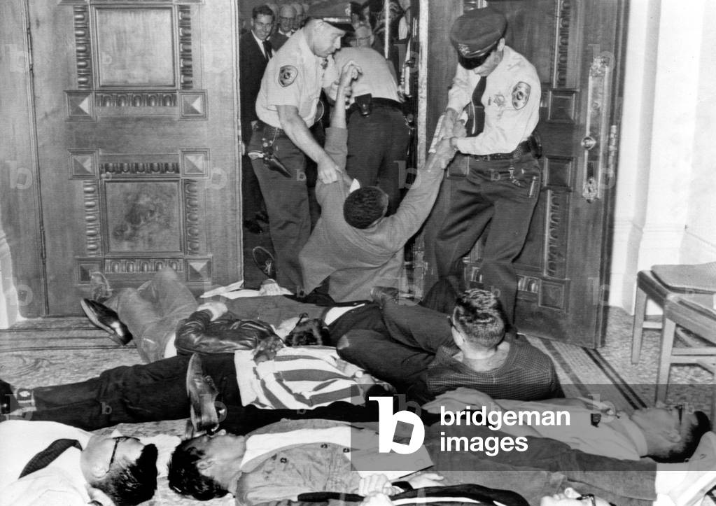 Demonstators removed by police in Sacramento, CA 6/14/63. CORE sponsored lie-in for fair housing bill.