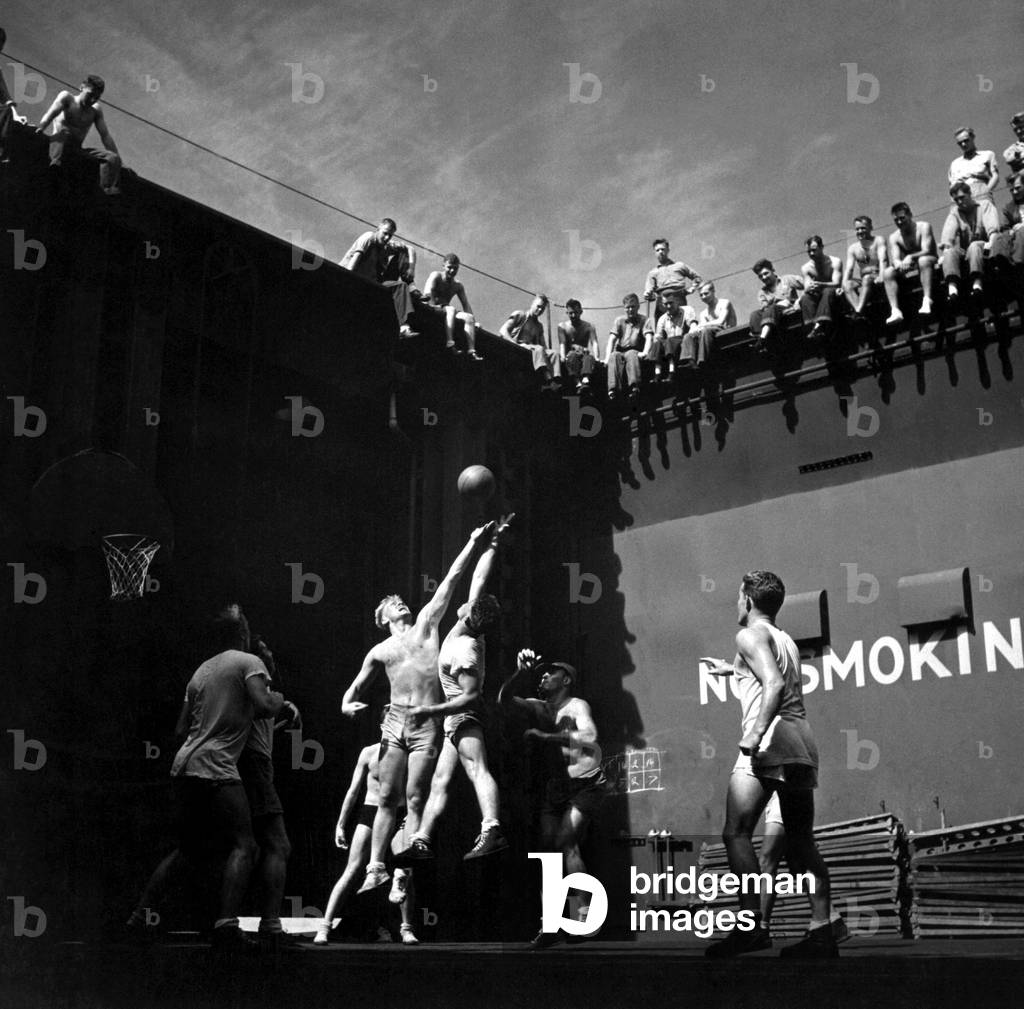 Navy pilots playing basketball in elevator well of USS MONTEREY during World War 2. Jumper at left is future U.S. President, Gerald R. Ford. Mid-1944 in the Pacific Ocean