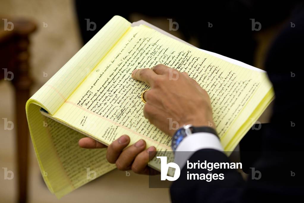 President Barack Obama holds his handwritten draft of the Nobel Peace Prize speech while working with his speechwriters. Dec. 9 2009.,