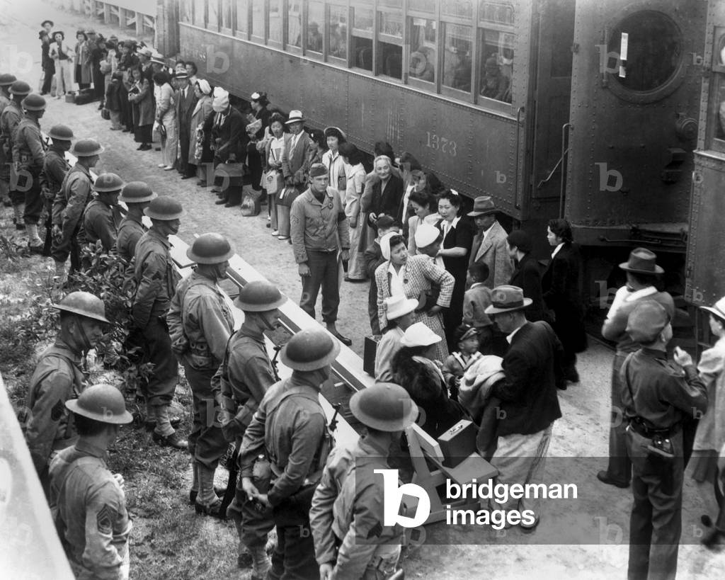 Japanese-Americans arrive by train at the Santa Anita Assembly Center from San Pedro, c. Located at the former Santa Anita race track, they lived here before transfer to inland internment for the duration of World War 2. Soldiers with rifles stand guardon the left