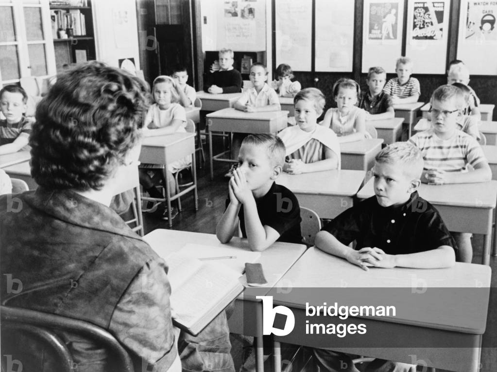 Second grade students listen as their teacher, reads a passage from the Bible in 1962 to substitute for the school prayers that were declared unconstitutional by the U.S. Supreme Court. In the following year, such Bible readings would also be banned by the Court