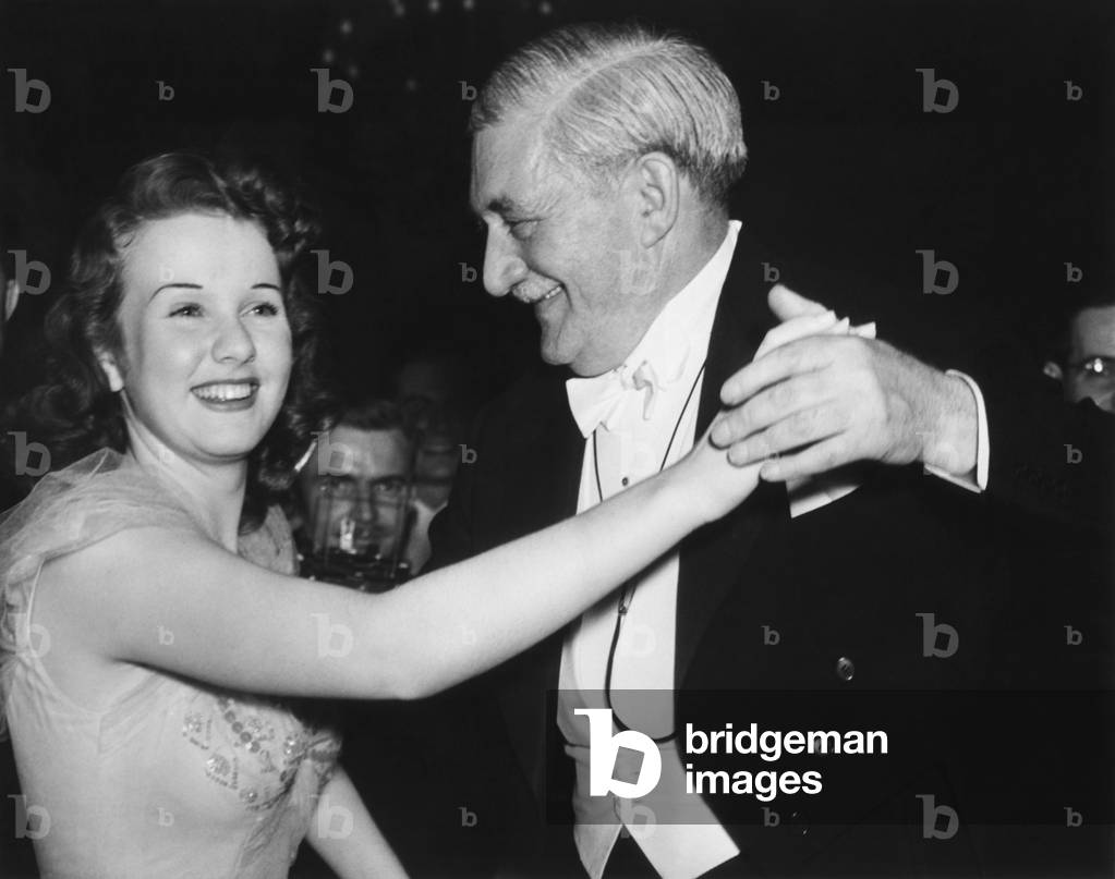 Deanna Durbin, film singing star, and William Knudson dance after the President's Birthday Ball. On Jan. 31, 1941, Knudsen, a previous target of FDR's 'Monopoly Committee' was serving the President as Defense Production Director. Durbin and Knudsen were guests at a gold plate breakfast at the White House, after the Ball