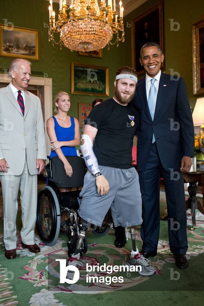 Petty Officer Taylor Morris was presented with a Purple Heart by Pres. Barack Obama. Morris also received a Bronze Star for valorous conduct. A quadruple amputee wounded in Afghanistan, he is fitted with prosthetics that allow him to walk and a motorized hand. Green Room of the White House, July 26, 2012