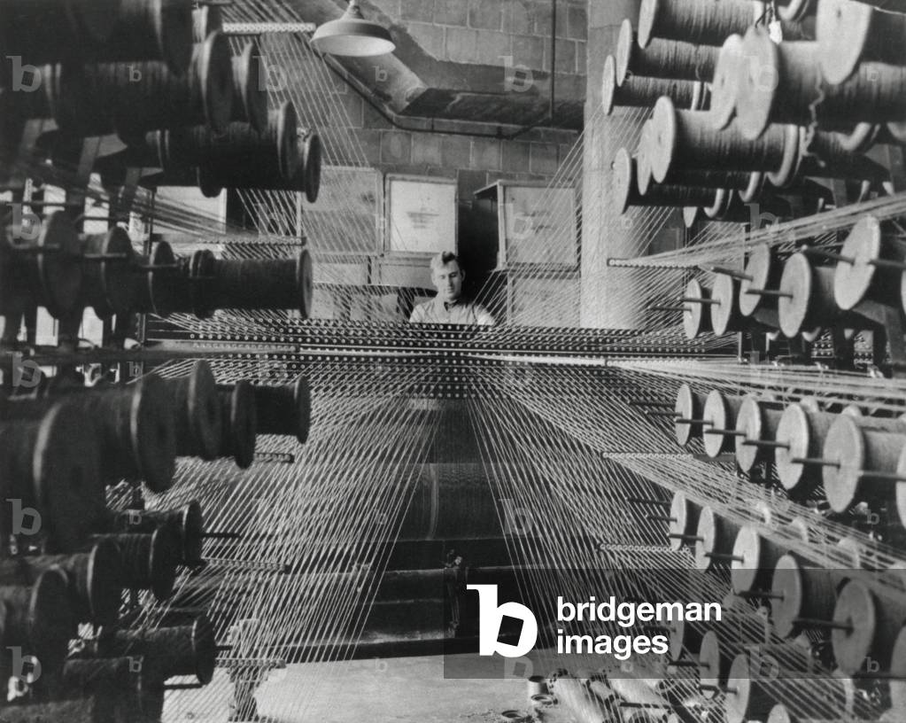 Workman operating an industrial loom strung with hundreds of wool threads. Chicago's Olsen Rug Company. c. 1950