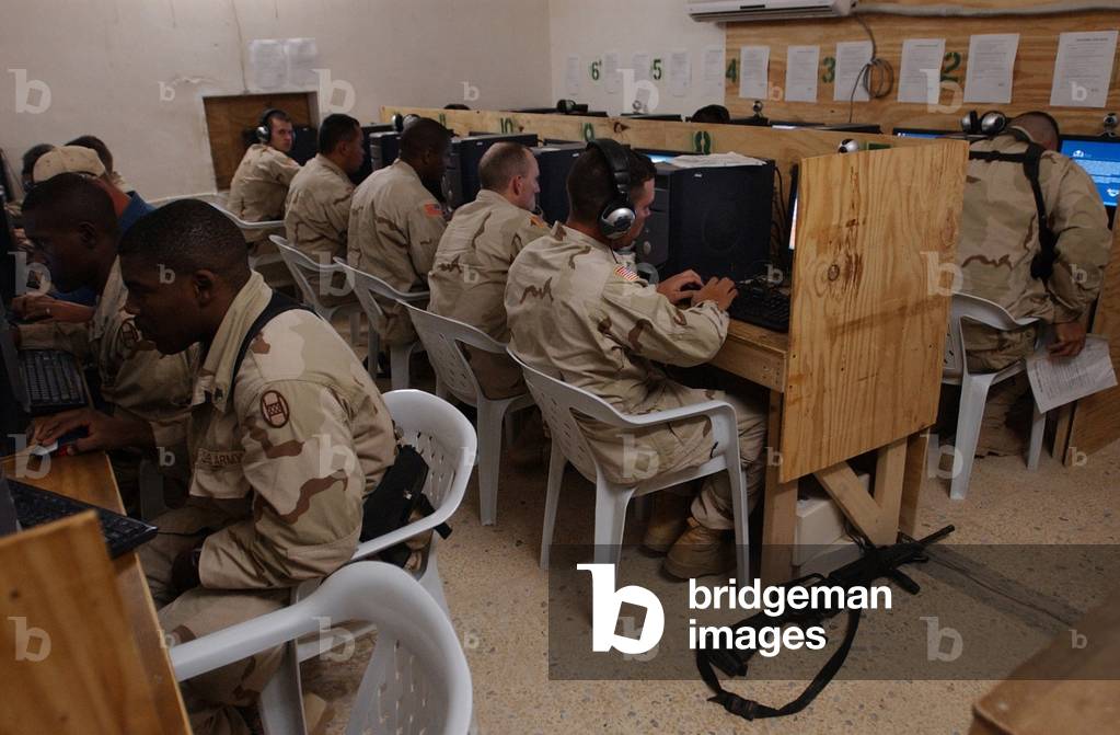 US Army soldiers e-mail their families before eating Thanksgiving dinner at Camp Cobra in Iraq on Nov. 25 2004