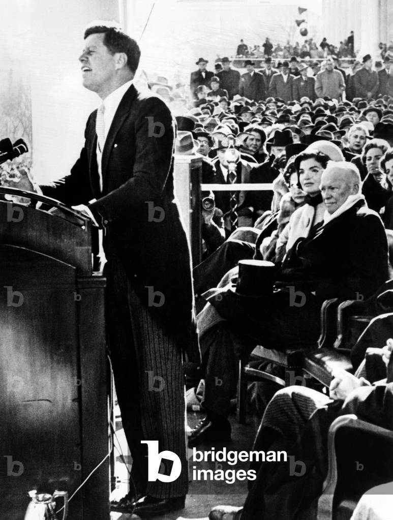 President John Kennedy delivering his inaugural address. Outgoing President Dwight Eisenhower, Jacqueline Kennedy look on. Jan. 20, 1961