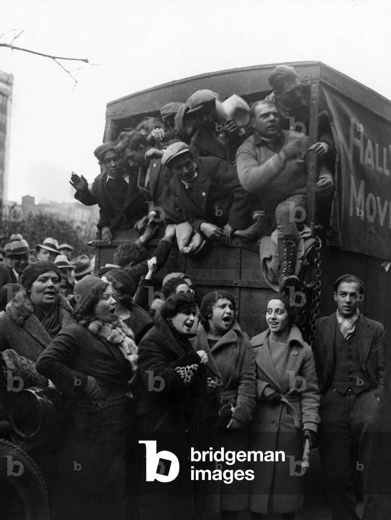 700 Hunger Marchers in trucks bound for Washington, D.C. Women marchers see them off with the labor carol, 'Solidarity Forever.' Nov. 30, 1932