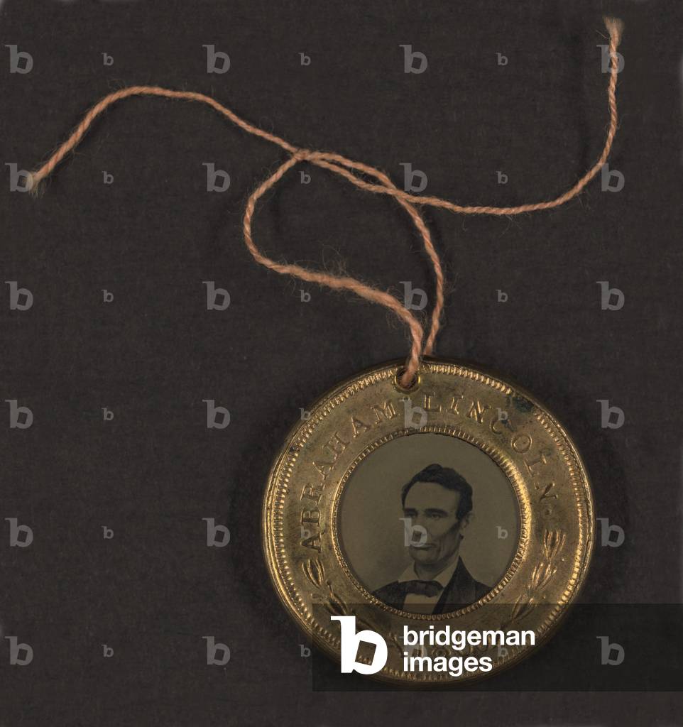 Campaign button for 1860 presidential election showing bust tintype portrait of Abraham Lincoln in a metal casing. Vice Presidential candidate, Hannibal Hamlin's, portrait is on the reverse side. 1860