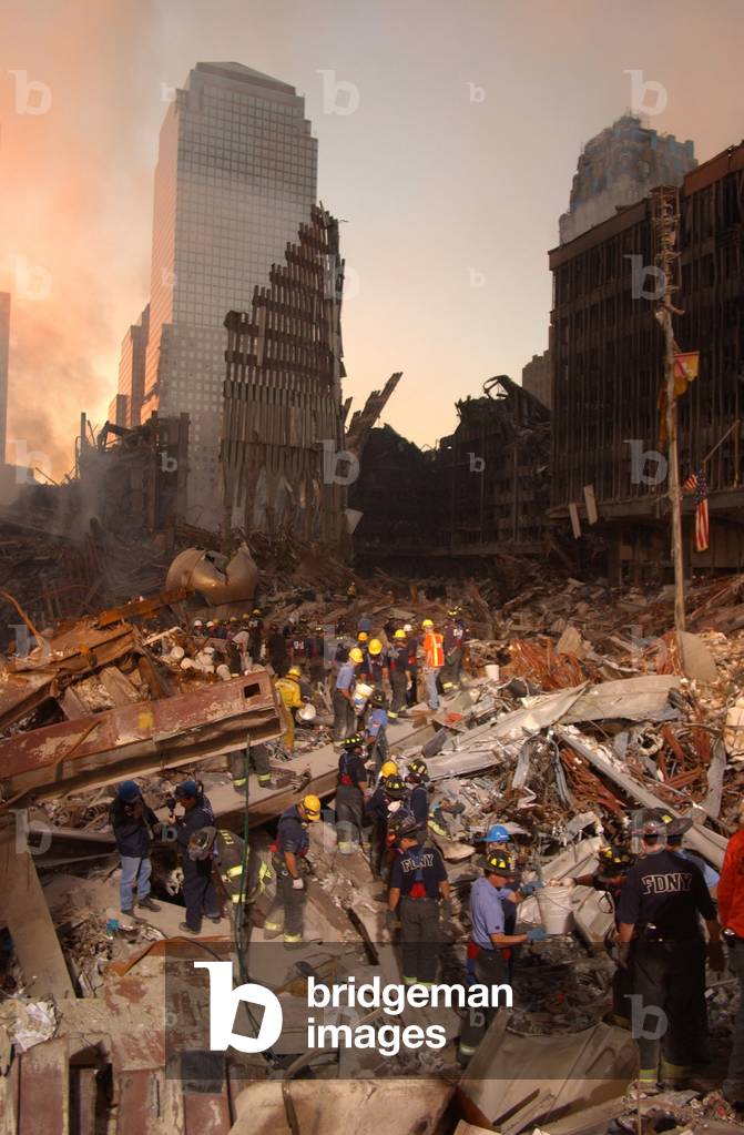 Firefighters and search and rescue teams work on 'The Pile' of rubble from the collapsed World Trade Center. In back ground is one of the buildings of the damaged World Financial Center. Sept. 16 2001