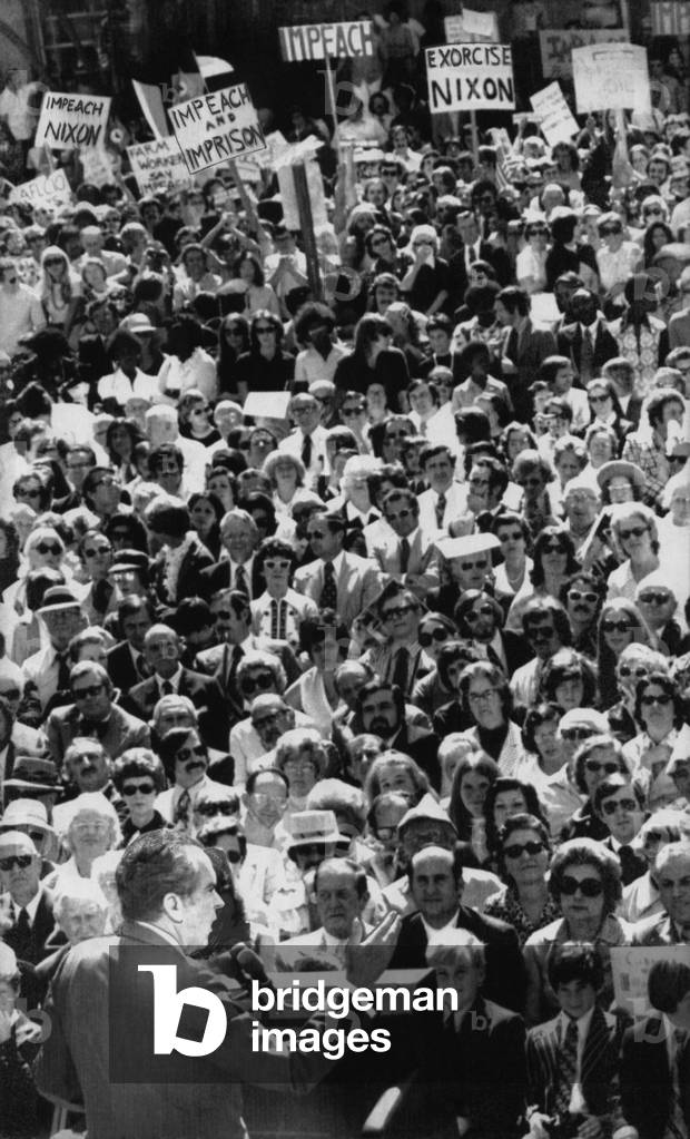 Nixon Presidency. US President Richard Nixon addresses a group of supporters, with protesters at rear of crowd, c.1970s