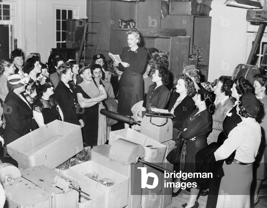 Vivien Kellems speaking to women in her Saugatuck, Connecticut, Cable-Grip factory. She is reading from a statute book, possibly on tax law. In 1948 she refused to collect withholding taxes from her employees as required by U.S. government, until government enforcement threatened to close her business. April 8, 1948