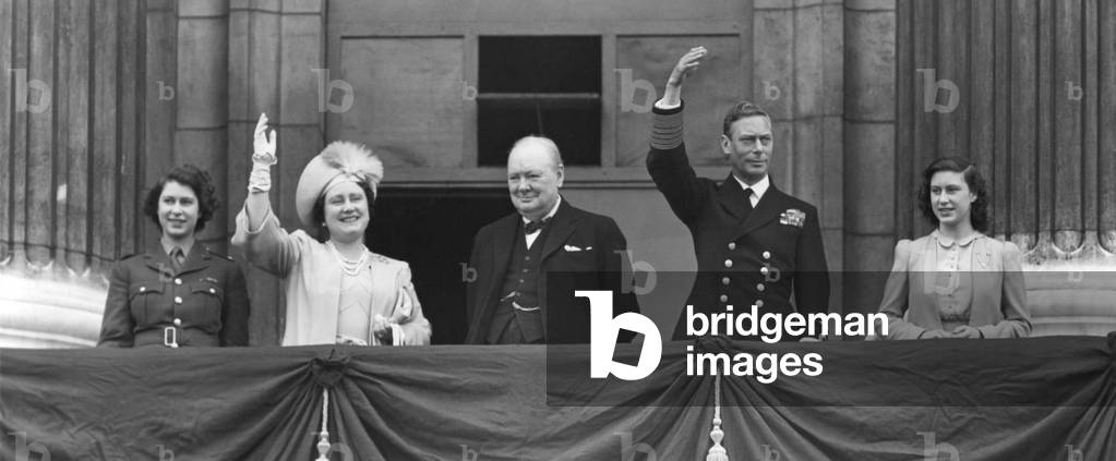 British Royal Family waves to crowds on Victory in Europe Day, May 8, 1945. Prime Minister Winston Churchill takes the central position of honor on the Buckingham Palace balcony. L to R: Princess Elizabeth, wear her ATS Uniform; Queen Elizabeth, Winston Churchill, King George and Princess Margaret.