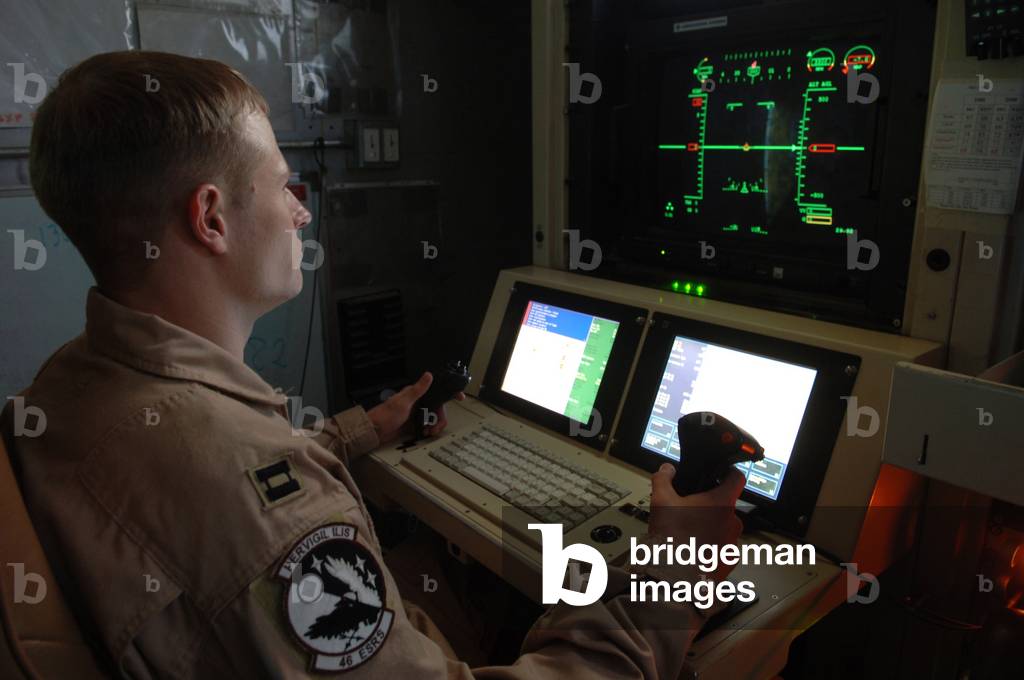 An Air Force officer maneuvers an unmanned Predator reconnaissance airplane over Iraq by remote control at Balad Air Base. Predators can be equipped with Hellfire missiles. Iraq. Nov. 5 2005