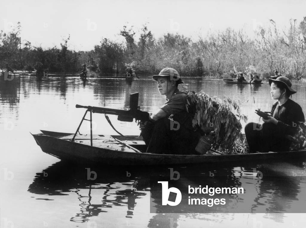 Viet Cong guerrillas in small boats patrol the Saigon River in South Vietnam in photo taken by communist forces